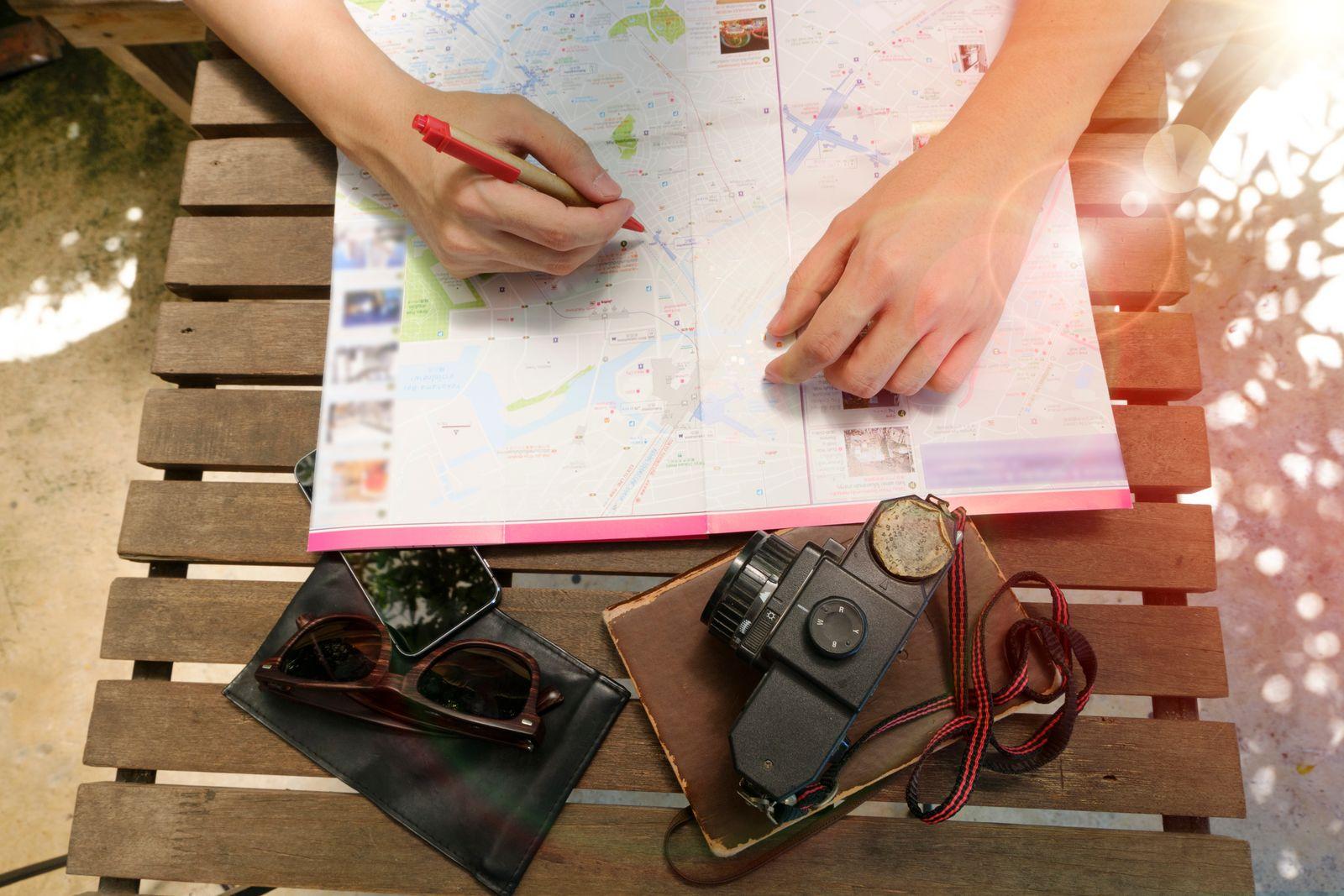 A map, a film camera, and a route planned by hand