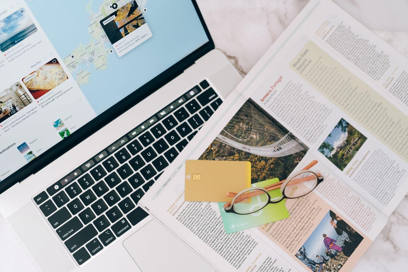 The research spread: laptop, map, cards, and a guidebook